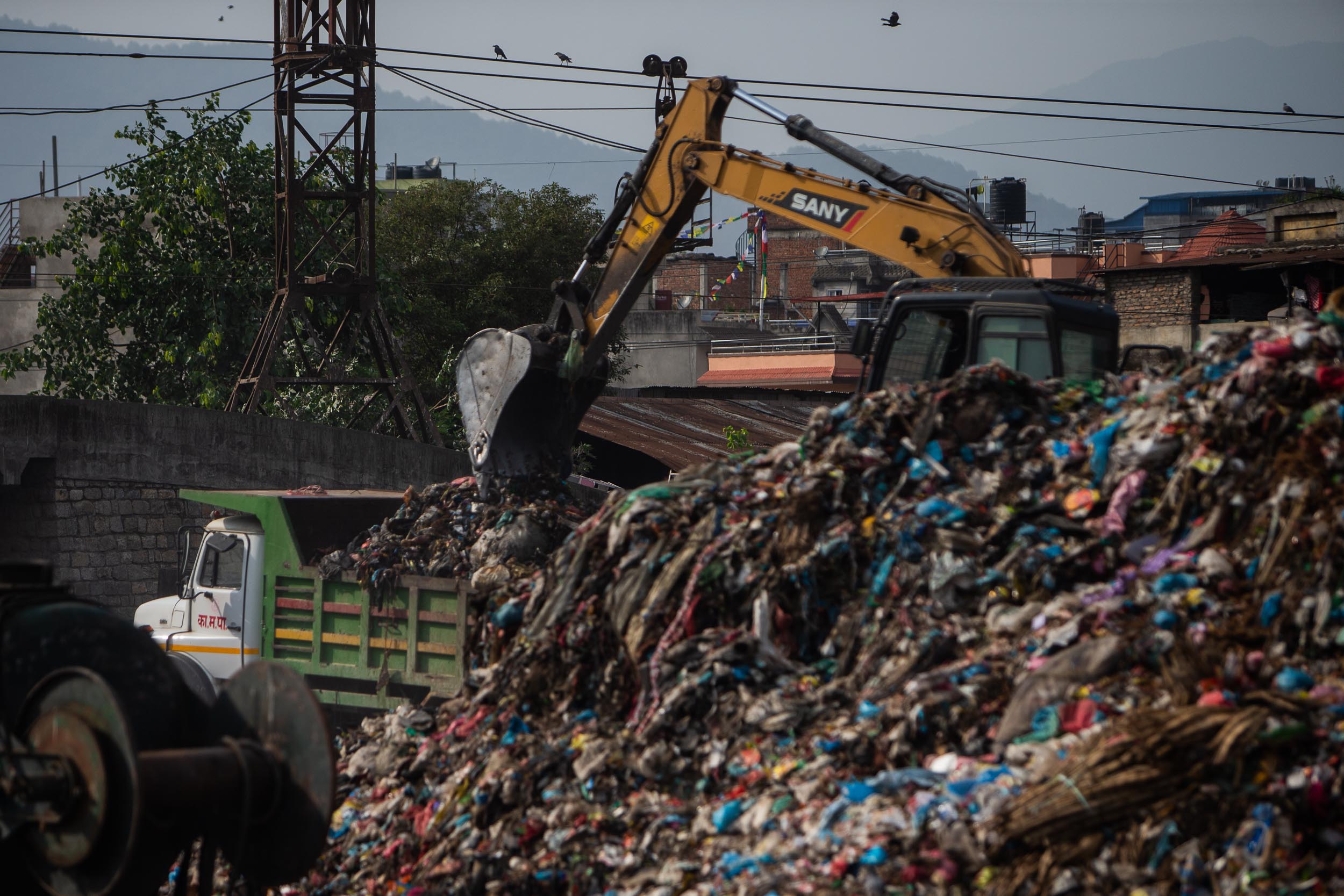 An excavator dumps waste into a truck which will transport the waste to Sisdole landfill area. (Image: Nishant Singh Gurung)